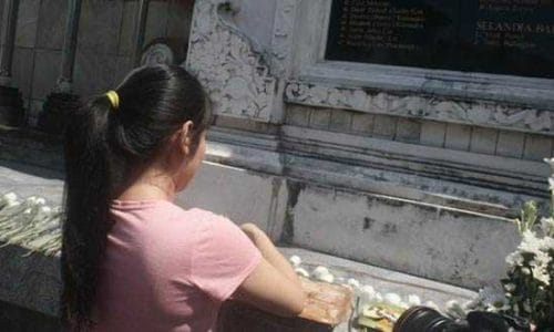 Seorang Gadis Bali sedang menghaturkan banten (sembahyang) di depan Monumen Bom Bali, di Ground Zero, Kuta Bali