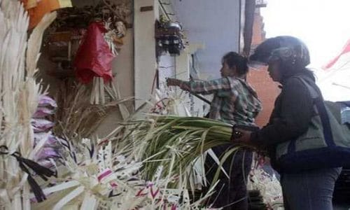 Seorang ibu sedang berbelanja perlengakapan upcara untuk persiapan Hari Raya Galungan dan Kuningan di Pasar Agung