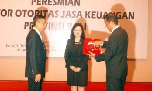 Zulmi, Kepala OJK Provinsi Bali menyerahkan Cinderamata kepada Made Mangku Pastika, disaksikan oleh Kusumaningtuti S. Soetiono (foto : sandrowangak)