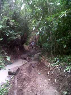 Warga terpaksa melewati jalan setapk yang licin dan berbahaya (foto: mingming)