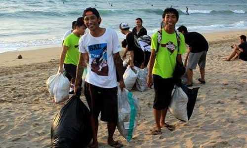 Relawan sedang membersihkan pantai Kuta (foto : ameliatagaroi)