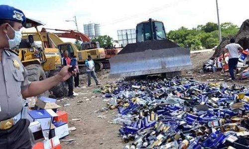 Ribuan botol miras berbagai merek dimusnakan menggunakan alat berat (Foto : kresia)