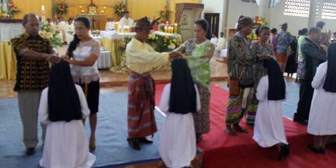 Orangtua menumpangkan tangannya kepada anaknya yang berkaul pertama di gereja Katedral Atambua (foto: felixali)