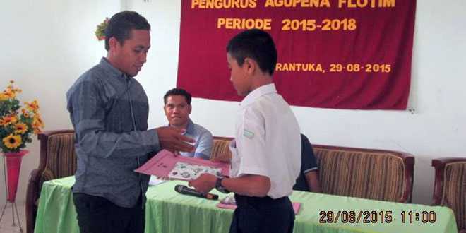 Salah seorang anggota Agupena, Pion Ratuloly saat memberikan buku kepada salah seorang siswa usai pelantikan (foto: humasagupenaflotim)