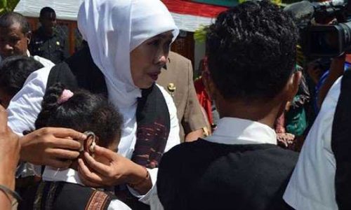 Kofifah Indar Parawansah, saat memasang alat bantu pendengaran kepada salah seorang siswa SLB di Alor (foto:iwankamaleng)
