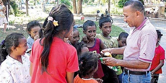 Foto : Pater Vande Raring saat melayani anak anak pengungsi Rokatenda (foto: ekomanek.svd)