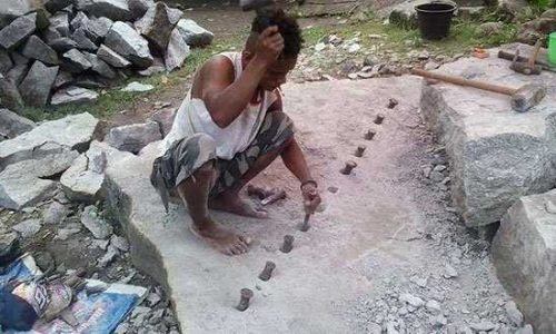 Foto : Rio Tukan saat sedang memacahkan batu sebagai pekerjaan sehari hari (foto: t.ruron)